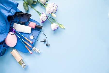 women's cosmetic bag with accessories on pale blue background. Close up. selective focus.の写真素材
