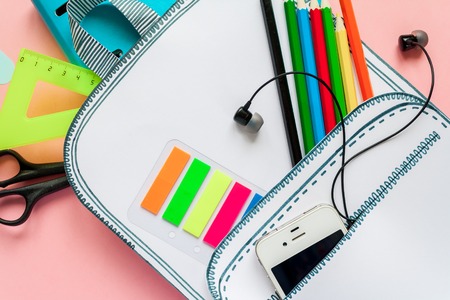 Creative school bag made of paper with school stationery on pink background. Trendy concept....