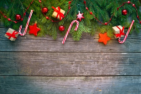 Merry Christmas and Happy New Year. Christmas Decorative Ornate Fir Glitter Natural Gifts and sweets on wooden Background. Red Holiday Concept.の写真素材