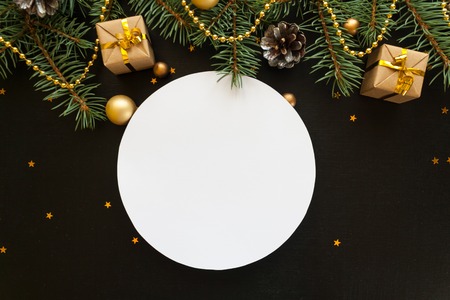 Merry Christmas and Happy new year. Round frame with branches firtree, gifts, Snowflakes on black backgroundの写真素材
