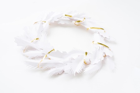 Merry Christmas and Happy New Year. Christmas wreath with gold ribbon made of white paperの写真素材