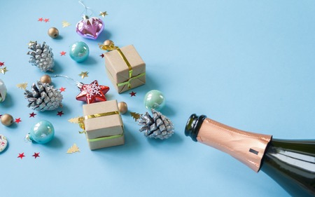 Champagne bottle with different christmas decoration on blue background. New year concept.の写真素材