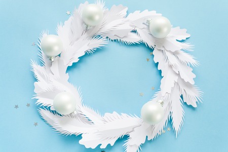 Christmas wreath made of white paper on blue backgroundの写真素材