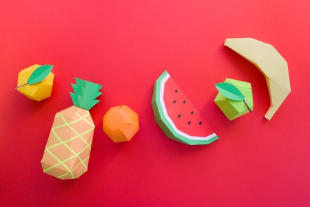 different exotic fruits made of paper on red backgroundの写真素材