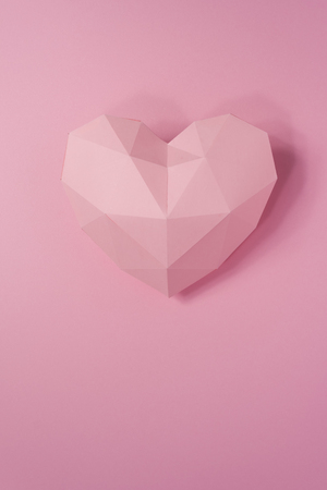 Paper hearth with shadow. Pink polygonal paper heart for Valentine's day or any other Love invitation cards.の写真素材