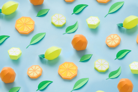 Pattern of fruit made of paper. Blue background. Flat lay. Orange, lemon and mandarine, summer conceptの写真素材