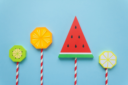 Fruit candies, concept of sweets, made of paper on blue backgroundの写真素材