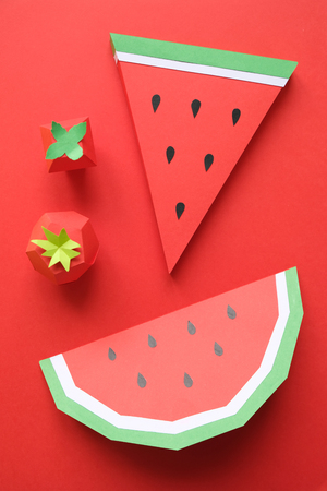 Red fruit made of paper. Watermelon and strawberry on red background. Red concept.の写真素材