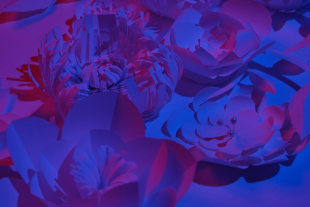 White paper flowers made of white paper on a white background illuminated by neon light. Trendy,...