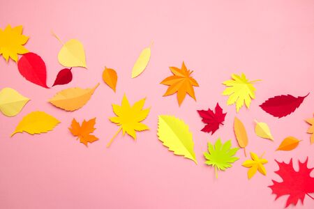 Leaves of paper fall red, orange, yellow leaf fall. Pink background. Handmade origami.
