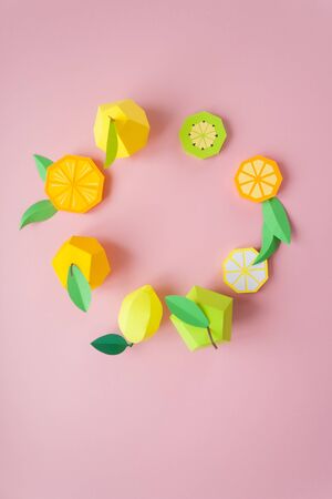 Round frame with exotic fruits made of paper on pink backgroundの写真素材