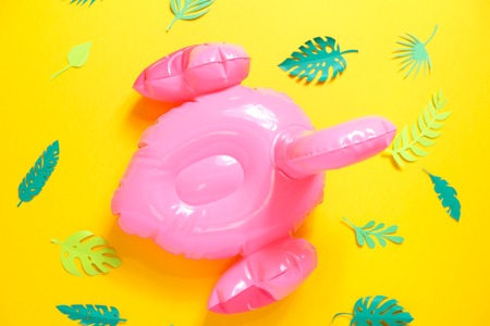 Inflatable pink flamingos on a bright yellow background.の写真素材