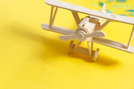 wooden toy airplane lucky tropical leaves cut from paper. The concept of summer and travel
