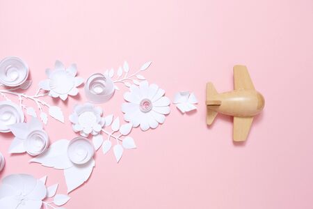 wooden toy airplane lucky white flower cut from paper. The concept of spring and travel