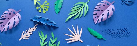 tropical leaves cut from paper on blue background. Dark blueの写真素材