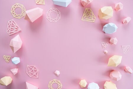 A variety of faceted gemstones, made of paper on a pink background. Jewellery concept