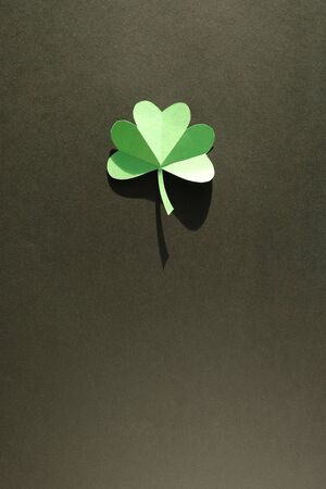 St. Patrick's day, Green Shamrock from paper on black background. Close up. Trend shadow