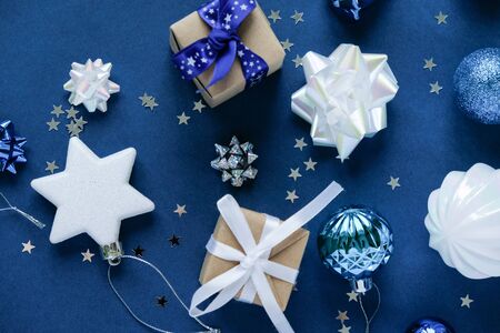 Merry christmas and happy new year. Christmas frame with white decorations and gift boxes on dark blue backgroundの写真素材