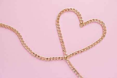 chain and heart, a gold chain laid out in the shape of a heart on a pink background. Valentine conceptの写真素材
