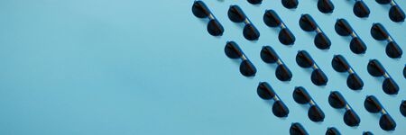 Sunglasses pattern on pastel blue background. Minimal summer concept.の写真素材