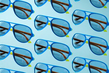 Sunglasses pattern on pastel blue background. Minimal summer concept.