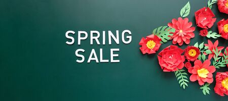 Spring sale. With red paper flowers and green leavesの写真素材