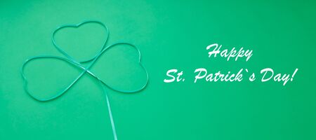 St. Patrick's day, clover cut out of paper on a green background