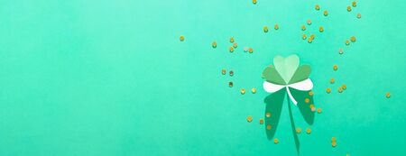 St. Patrick's day, pattern of clovers cut out of paper on a green shiny backgroundの写真素材
