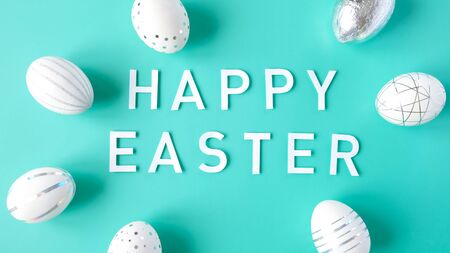 White easter eggs with silver decor and white flowers. Happy Easter concept.の写真素材