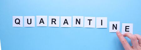 The word quarantine written on a blue hospital background. Concept of quarantine and isolation. Long format for webの写真素材