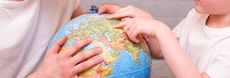 Dad and son look at the globe. Home education. Close up