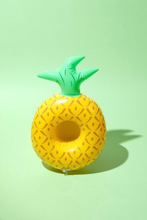 Yellow inflatable pineapples on a green background. Trendy modern elementの写真素材