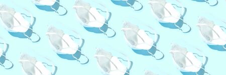 Many medical masks on the blue colored background to cover the mouth and nose for protection from virus and bacteria on a blue background. Epidemic concept. Regular pattern.の写真素材