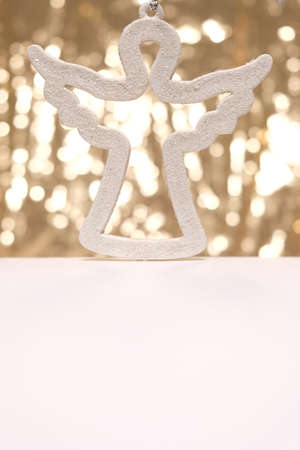 Christmas angel on Blackground of abstract glitter lights. Gold and white. Blurredの写真素材