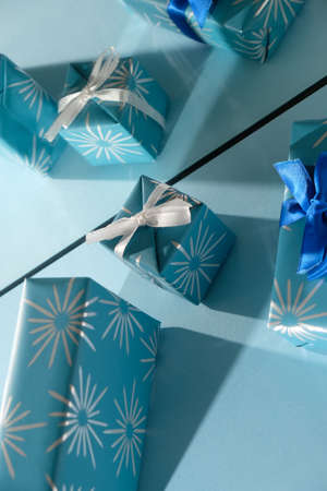 Blue and silver xmas ornaments on bright holiday background with space for text.