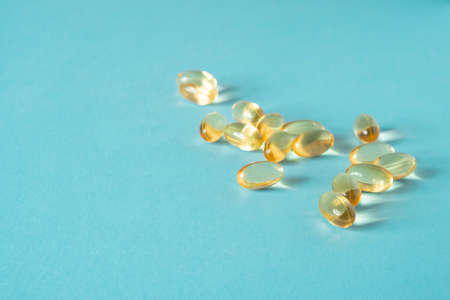 Pile of capsules Omega 3 on blue background. Close up, top view, high resolution product.の写真素材
