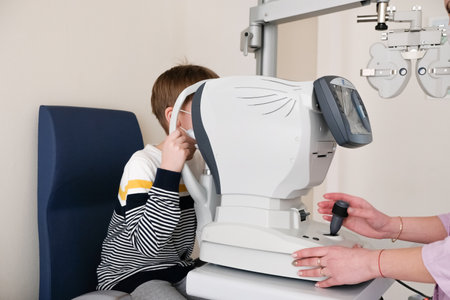 Checking the childs vision. Optometrist examines a patient s boy with special ophthalmic equipment...