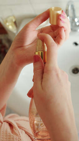 The girl squeezes the care product into the palm of her hand. Cleanliness and body care concept.