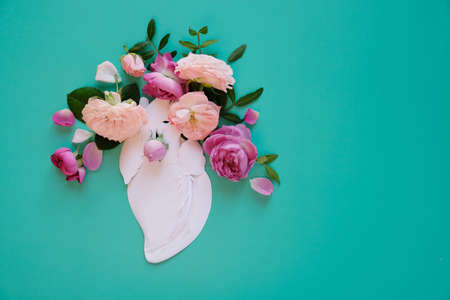 Human heart organ concept with flowers as a circulatory anatomy made of paper as a medical health care symbol of an inner cardiovascular body part.の写真素材