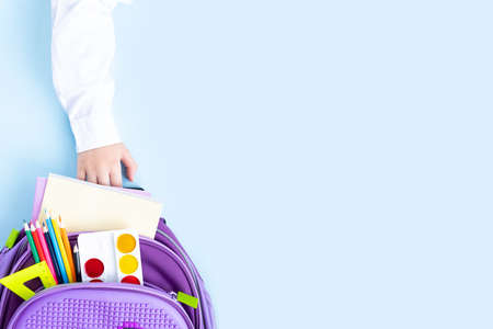 Back to school concept. Backpack with school supplies on blue background. Top view. Long format for webの写真素材