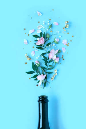 Champagne bottle with different flower on blue background. Celebrate conceptの写真素材