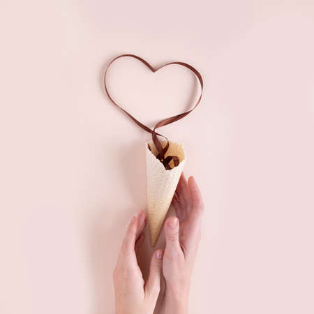 Waffle cone with brown ribbon in the shape of heartの写真素材