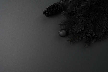 Happy New Year and Merry Christmas black concept. Background of black branches of a Christmas tree on a black background. Long format for webの写真素材