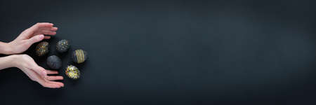 Black easter eggs with gold pattern on blackの写真素材