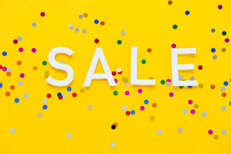 Sale with colorful confetti on yellow backgroundの写真素材