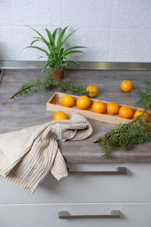 Tangerines on a wooden plate in a white kitchen. New Year's mood, the holiday is comingの写真素材