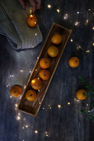 Christmas or New Year still life of tangerines lying on wooden rectangular plateの写真素材