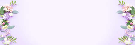 Floral frame with pink roses, white flowers, branches, leaves and petals on purple background. Flat lay, top viewの写真素材