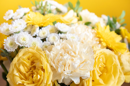 Bouquet of white and yellow flowers on a yellow backgroundの写真素材