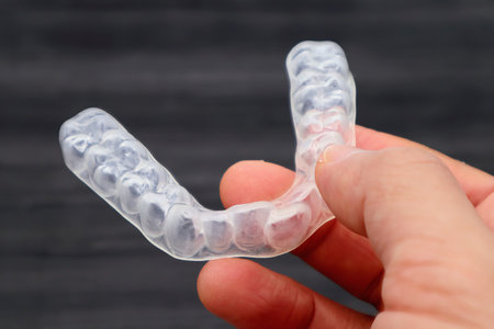 A person holding a mouthpiece for orthodontics